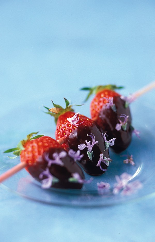 Φράουλες με σοκολάτα και άνθη δεντρολίβανου 24 φράουλες
200 γραμμ. σοκολάτα κουβερτούρα
200 ml κρέμα γάλακτος
2 κ.σ. άνθη δεντρολίβανου 
8 καλαμάκια
